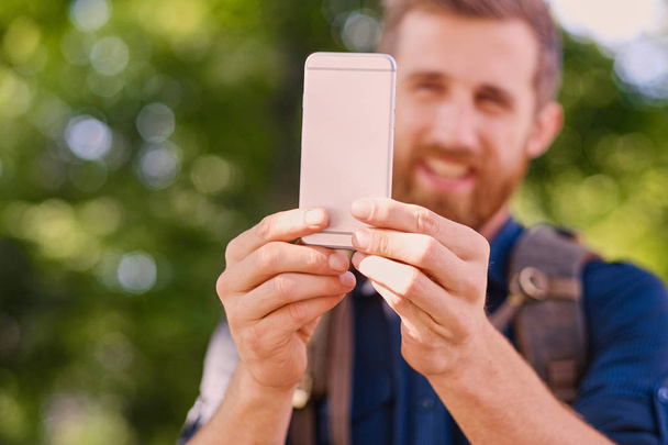 Man holds silver smart phone - Foto, Imagen