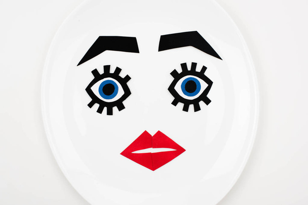 paper face with makeup on plate  - Foto, Imagen