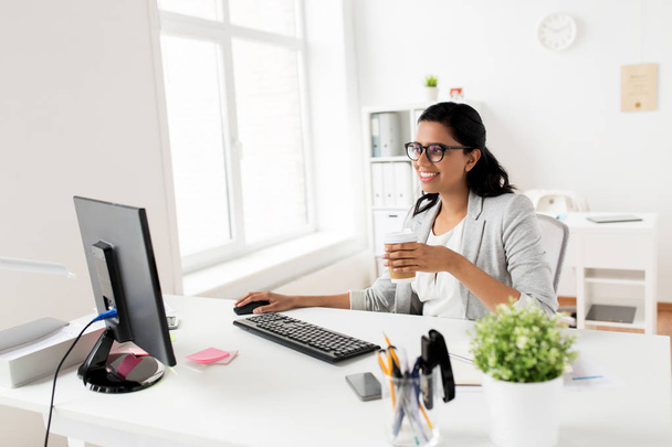 businesswoman drinking coffee or tea at office - Foto, Bild