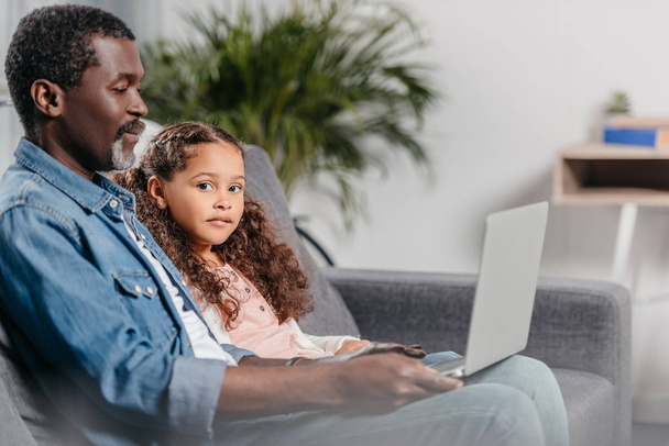Pai com filha usando laptop
  - Foto, Imagem