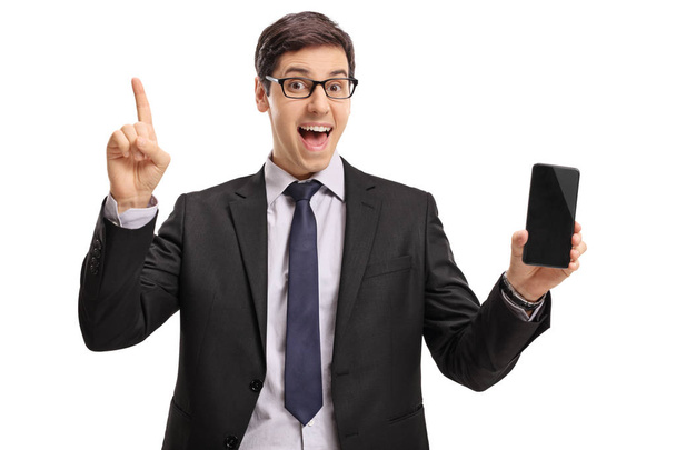 Businessman holding a phone and pointing up - Photo, Image