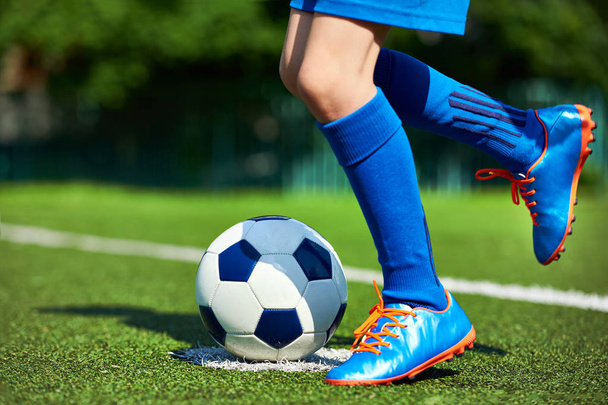 Legs football player boy in boots with ball on grass - Φωτογραφία, εικόνα