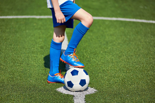 Boy soccer in football boots with ball on grass - Foto, Bild