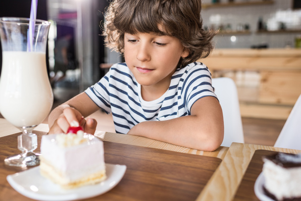 boy with piece of cake in cafe - Foto, afbeelding