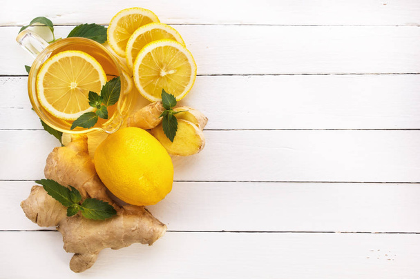 Tea, lemon, ginger, mint on white boards - Fotoğraf, Görsel