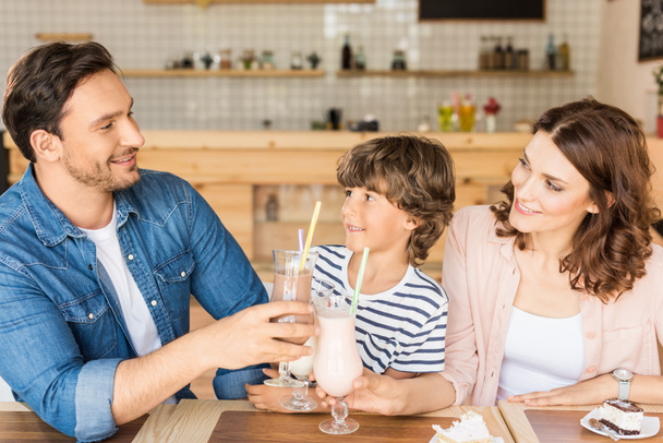 Семья пьет молочные коктейли в кафе
 - Фото, изображение