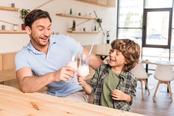 son and father drinking milkshakes - Foto, afbeelding