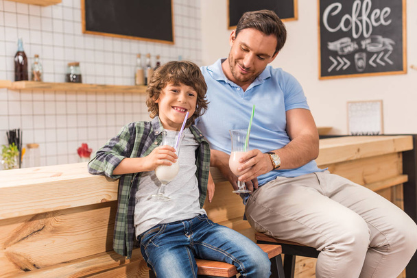 son and father drinking milkshakes - Foto, imagen