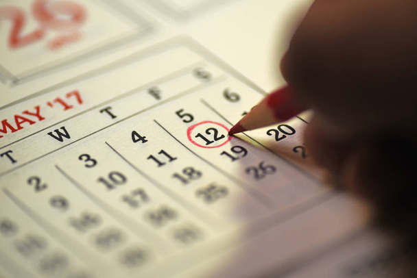 Doce días del mes marcados en el calendario con lápiz rojo
 - Foto, Imagen