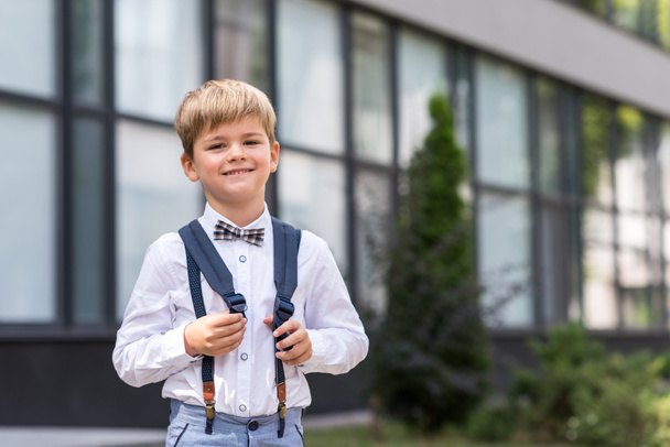 cheerful schoolboy near school - Foto, afbeelding