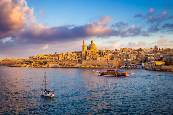 Valletta, Malta - Sail boats at the walls of Valletta with Saint Paul's Cathedral and beautiful sky and clouds in the morning - Photo, Image