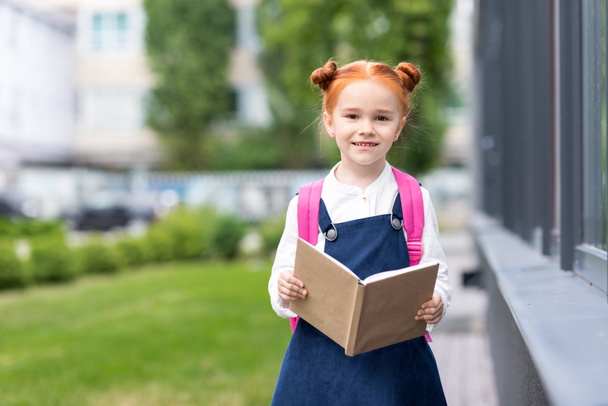 redhead schoolgirl holding book - Foto, afbeelding