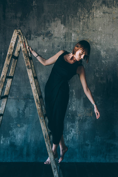 young beautiful woman indoor looking away posing on a ladder - model, fashion, influencer concept - Fotoğraf, Görsel
