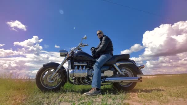 Näkymä moottoripyörällä istuvasta miehestä aurinkolasit päässä
. - Materiaali, video