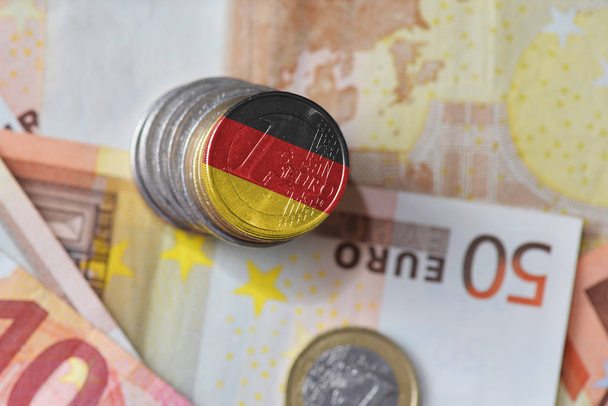 κέρμα του ευρώ με την εθνική σημαία της Γερμανίας σχετικά με το ιστορικό χρήματα με τραπεζογραμμάτια ευρώ. - Φωτογραφία, εικόνα