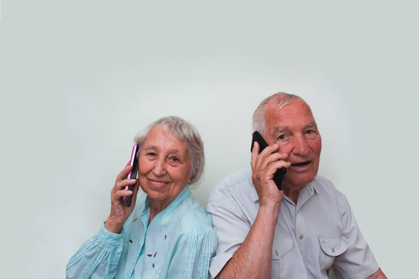 Senior couple at home using smartphones - Fotó, kép