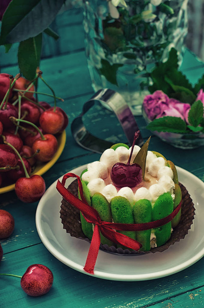 Krémový dort s višněmi. Dřevěné tyrkysové pozadí. Pohled shora. Detail - Fotografie, Obrázek