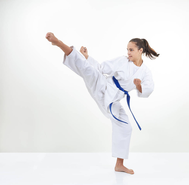 Una sportiva adulta in karategi batte calcio
 - Foto, immagini