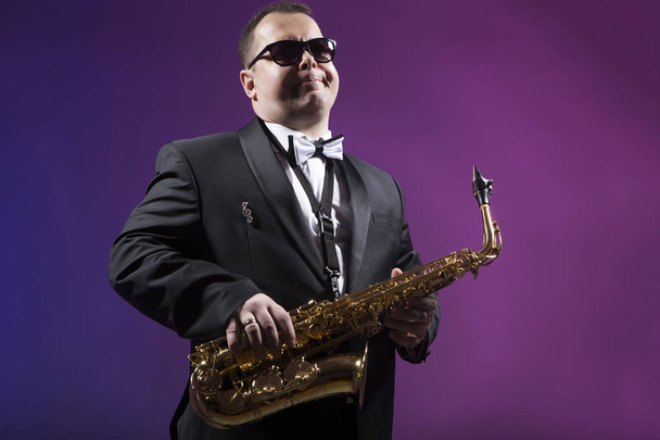 Saxophonist is playing the saxophone - Фото, изображение