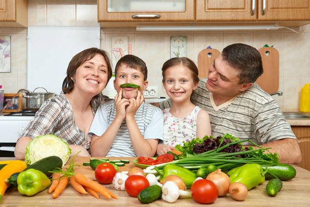 retrato familiar en el interior de la cocina en casa, frutas y verduras frescas, concepto de comida saludable, mujer, hombre y niños cocinar y divertirse
 - Foto, imagen