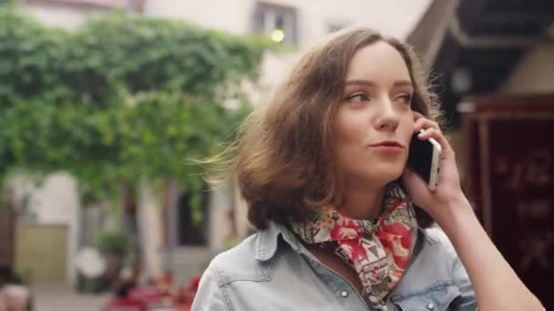 Girl is Talking on the Phone During Walk on Street in European Town - Materiaali, video