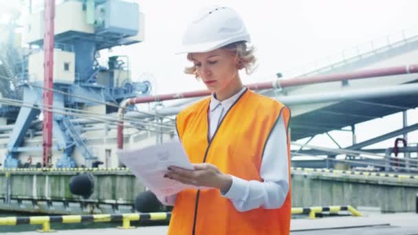 Woman in Hard Hat and Safety Vest in Industrial Environment - Footage, Video