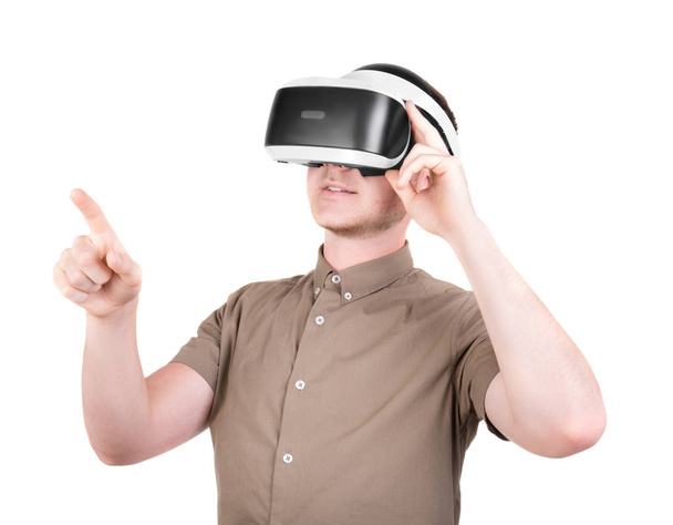 A young man is using a 3D virtual reality headset, isolated on a white background. New and professional audio equipment. A guy in virtual reality goggles. VR Glasses. - Foto, imagen