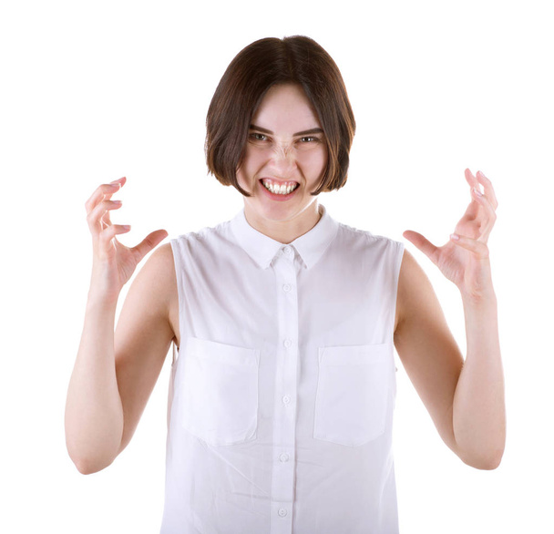Депрессивная молодая женщина с тёмной стрижкой и в обычной белой блузке, изолированная на белом фоне. Злая и разочарованная офисная леди
. - Фото, изображение