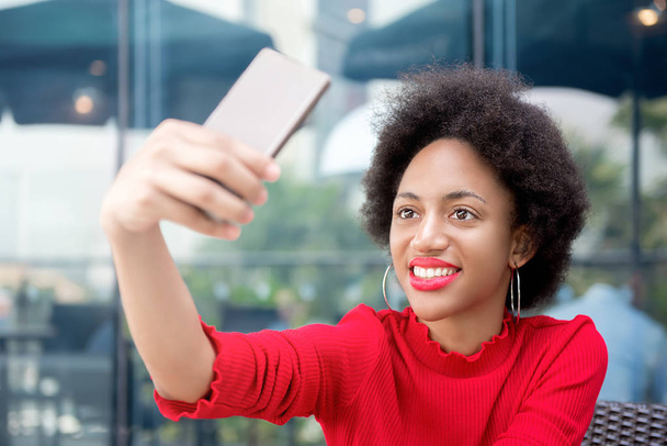 Afro woman taking selfie with smartphone in coffee shop - Fotoğraf, Görsel
