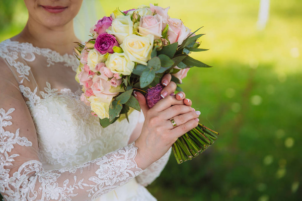 Closeup of bride hands holding beautiful wedding bouquet with white and pink roses. Concept of floristics - Valokuva, kuva