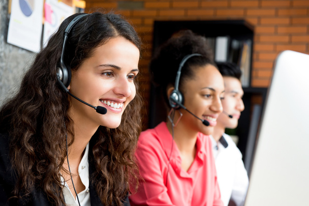 Empresária sorridente trabalhando em call center com sua multietnia
 - Foto, Imagem