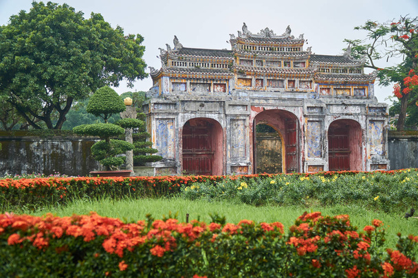 Ворота, растения, цветы и деревья в тумане. Парк в имперском городе во Вьетнаме
. - Фото, изображение