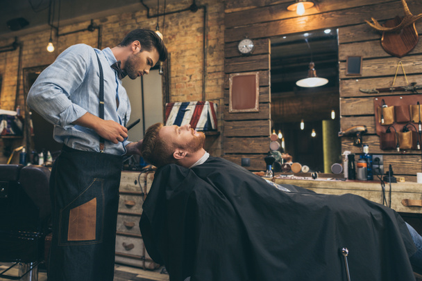 barber cutting hair of customer - Fotoğraf, Görsel