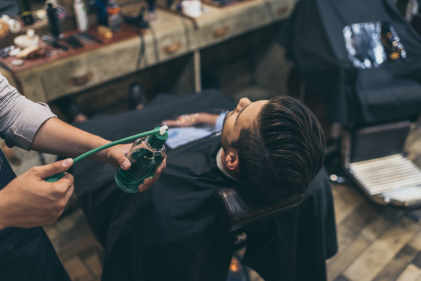 barber applying perfumes to customer - Photo, Image