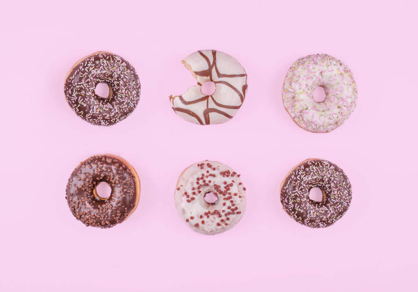 Colorful donuts on pink background. - Zdjęcie, obraz
