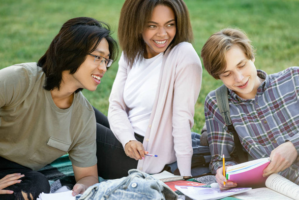 Smiling students studying outdoors. Looking aside. - Foto, imagen