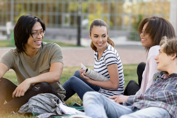 Cheerful group of multiethnic students studying outdoors. - Foto, imagen