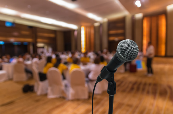 Microphone over blurred conference hall interior  - Valokuva, kuva
