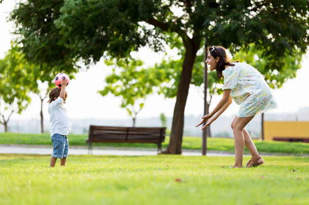 Beautiful young mother with her son having fun in the park. - Photo, Image