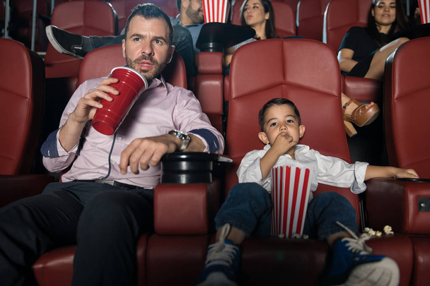 Homme et fils regardant un film au cinéma
 - Photo, image