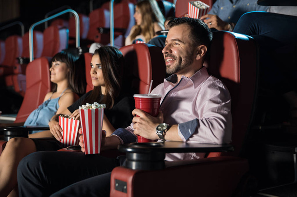 Люди смотрят кино и едят попкорн
 - Фото, изображение