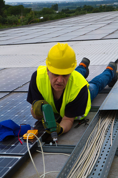 Arbeiten auf einem Dach zur Montage von Photovoltaikmodulen - Foto, Bild
