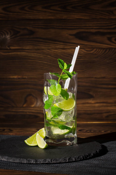 close-up of Fresh drink with mint leaves, ice and lemon on wooden background. - Valokuva, kuva