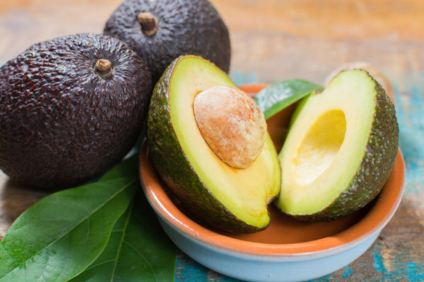 Ripe fresh avocado with leaves on blue wooden table - healthy food concept - Photo, Image