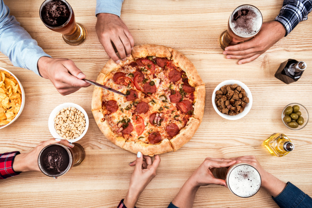 Ystävät syövät pizzaa yhdessä
 - Valokuva, kuva