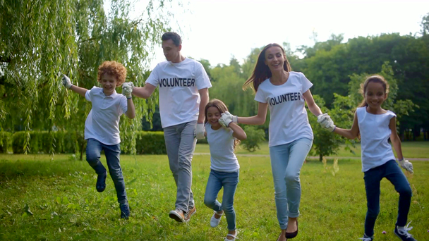 Group of radiant volunteers jumping and having fun outdoors - Footage, Video