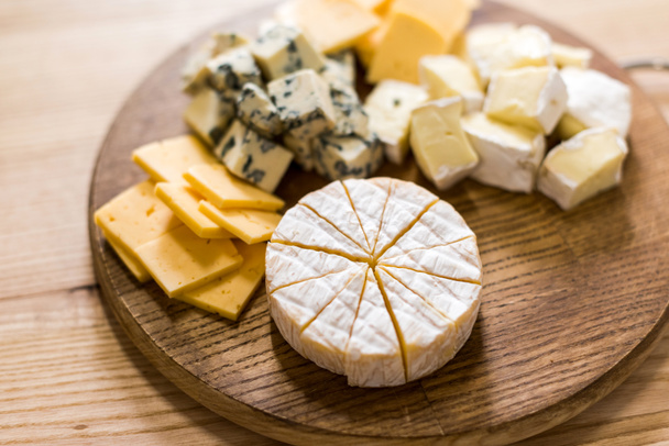 különböző sajt azonos fajtájú fából készült táblán - Fotó, kép