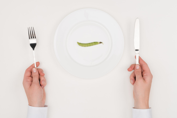 hands, cutlery and pea on plate - Photo, Image