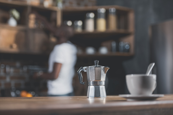 кавовий горщик і чашка на столі
 - Фото, зображення