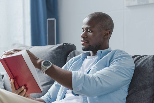 african american man reading book  - Фото, изображение